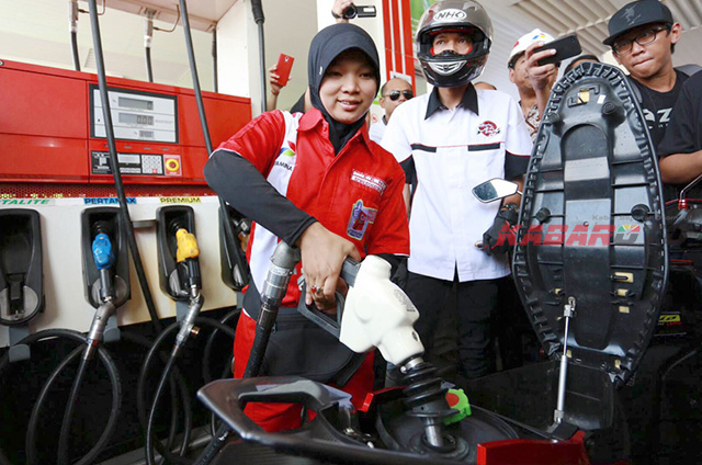 Seorang petugas spbu bernama Erna mengisi Pertalite ke motor milik bikers dari club Yamaha Mio (foto: rizky Fitrianto) 