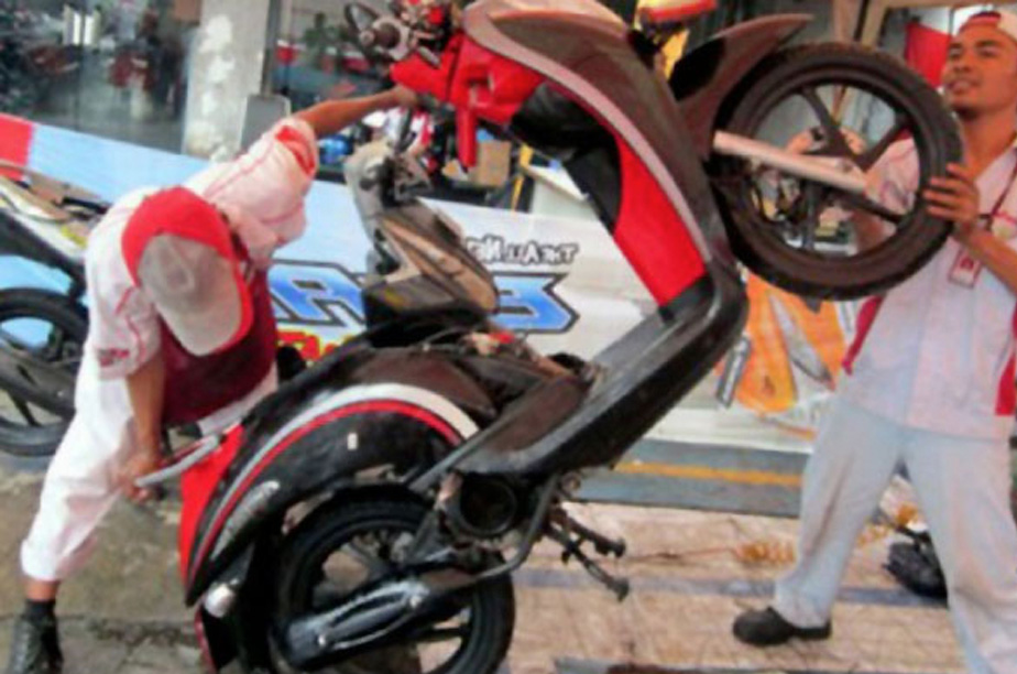 Mekanik sedang menunggingkan motor (foto: ist)