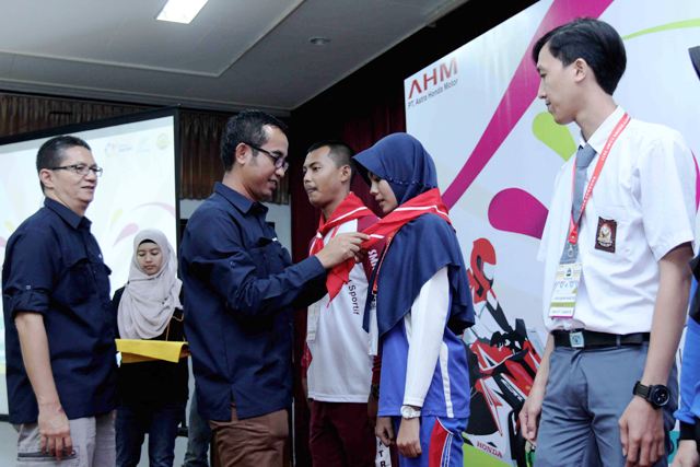 Deputy Head of Corporate Communication AHM Ahmad Muhibbuddin (kiri kedua) bersama Manager CSR AHM Yudi Yozardi (kiri) menyematkan slayer kepada perwakilan Duta Safety Riding